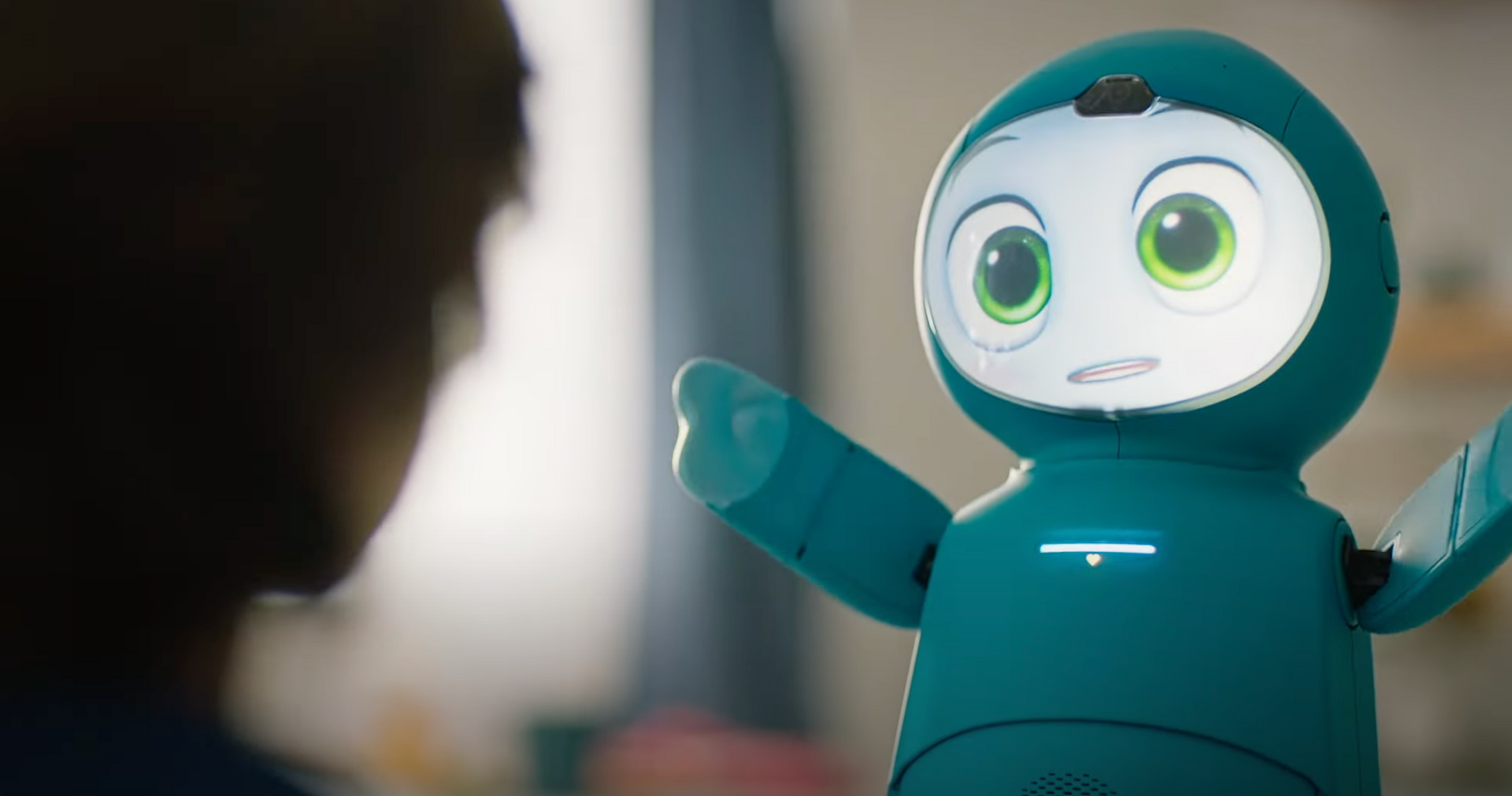 Moxie Robot doing an activity with kid with arms raised 